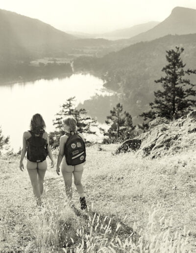 Naked hikers in nature with backpacks